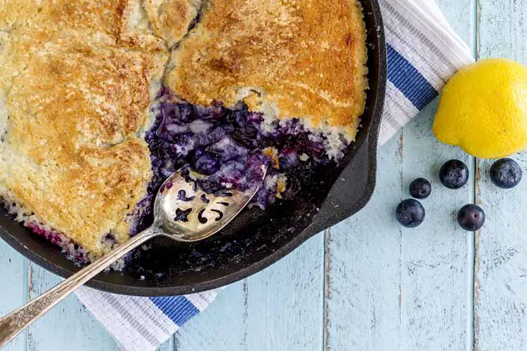 Close up of homemade fresh blueberry cobbler baked in cast iron skillet pan
