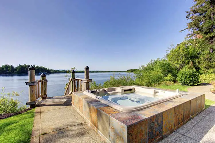 Backyard area with hot tub and awesome water view.