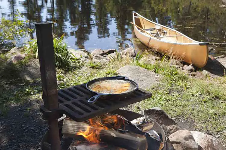Fish cooking in a frying pan over an open fire