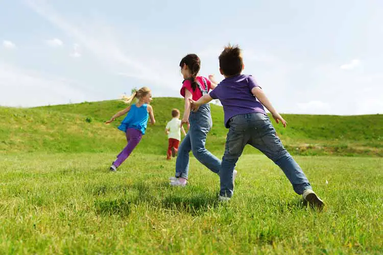 group of happy kids running outdoors