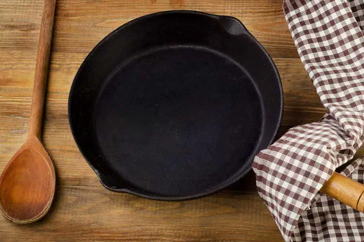 Cast iron skillet on rustic wood background