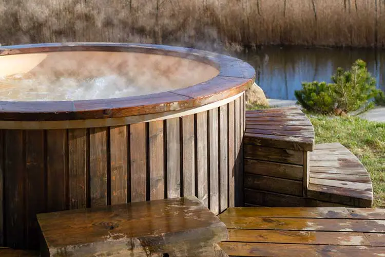 How water swirling in wooden hot tub outside in nature
