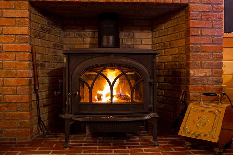 Fire burning in a wood stove at a lodge cabin.