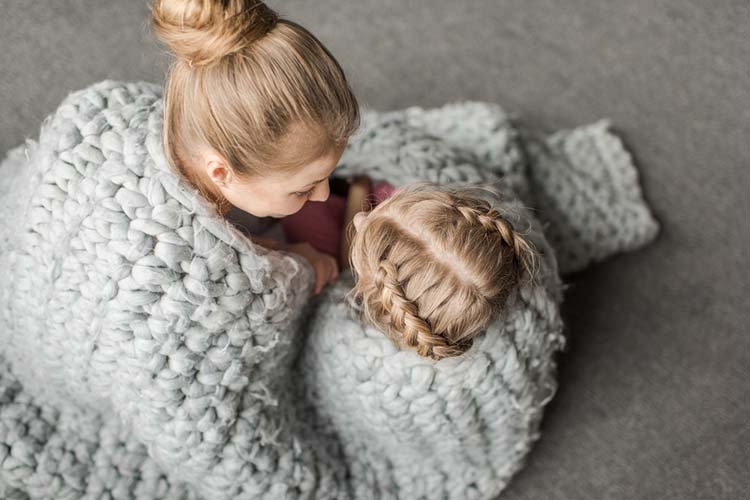 overhead view of mother and daughter hugging and sitting