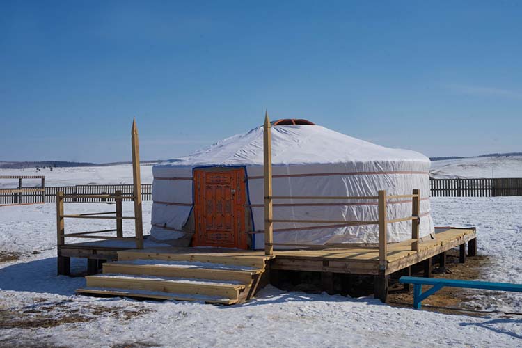 white yurt in the winter in the sun during the day