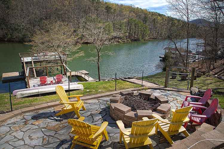 A seating area around a fire pit overlooking a private dock on Smith Mountain Lake.